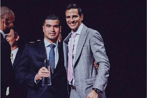 Ken Lear presenting an award to a member of his team on stage